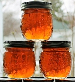 three small jars of dark brown maple syrup