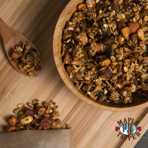 bowl of homemade granola with nuts, seeds, and a spoon on a wodden talbe
