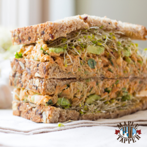 Two halves of a chickpea salad sandwich stacked on top of each other.